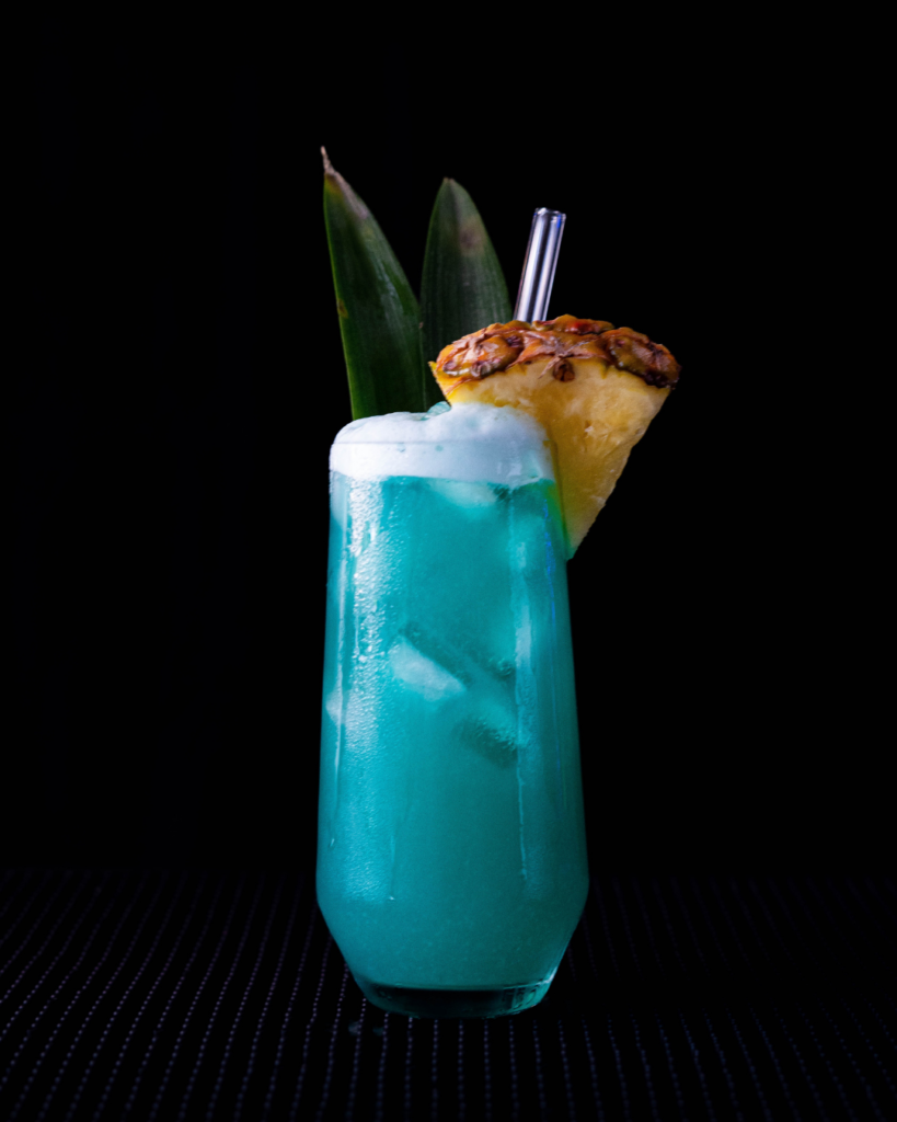 The Blue Hawaii on a bar countertop with a black background