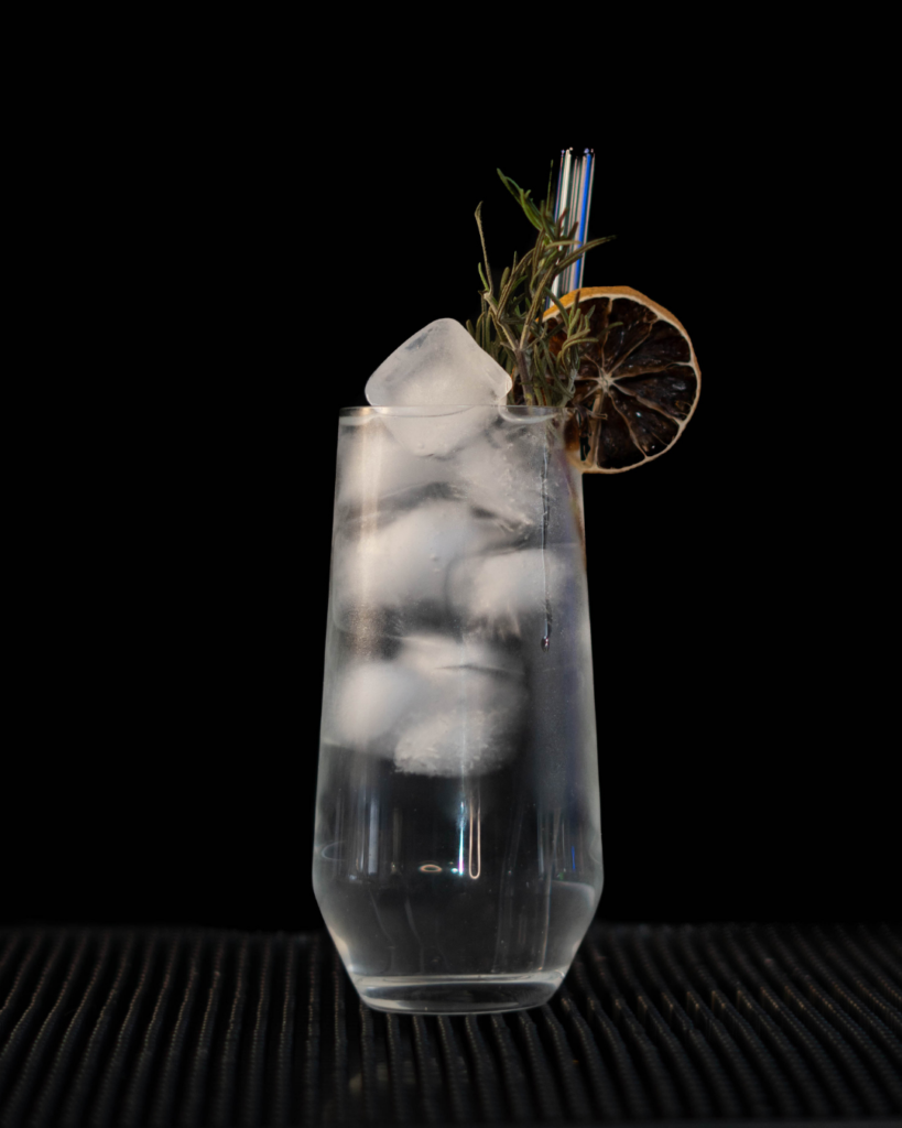 Fluère & Tonic on a bar countertop with a black background