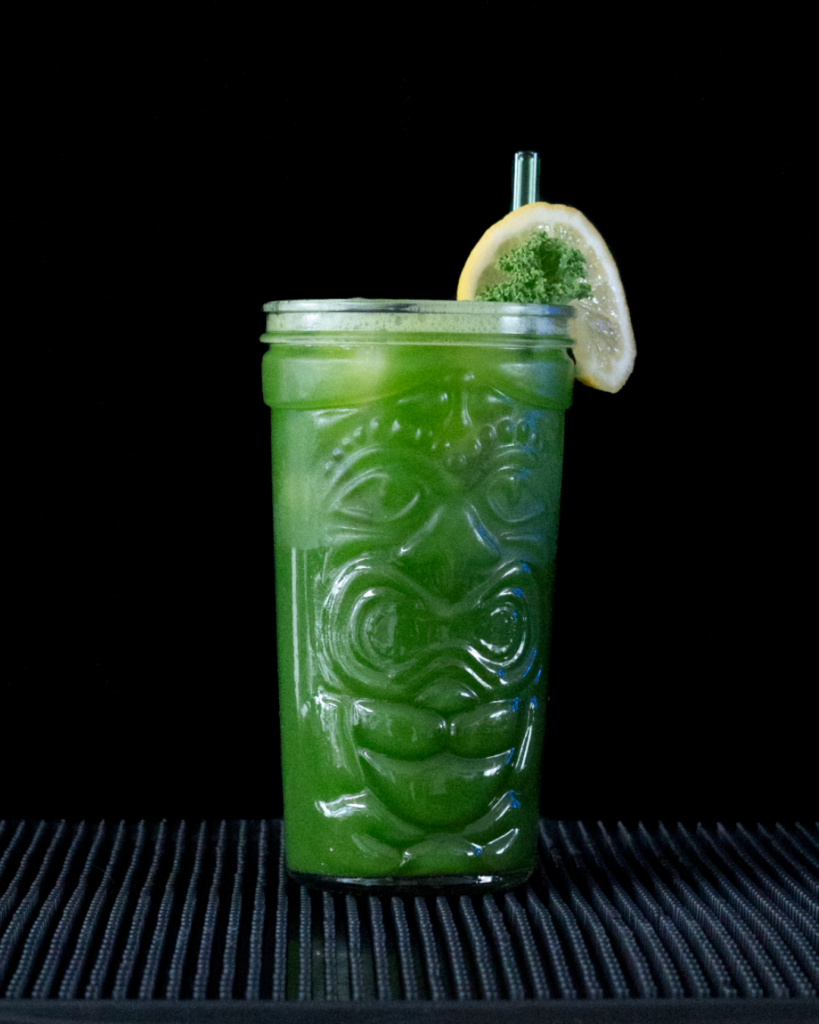 Green juice on a bar countertop with a black background