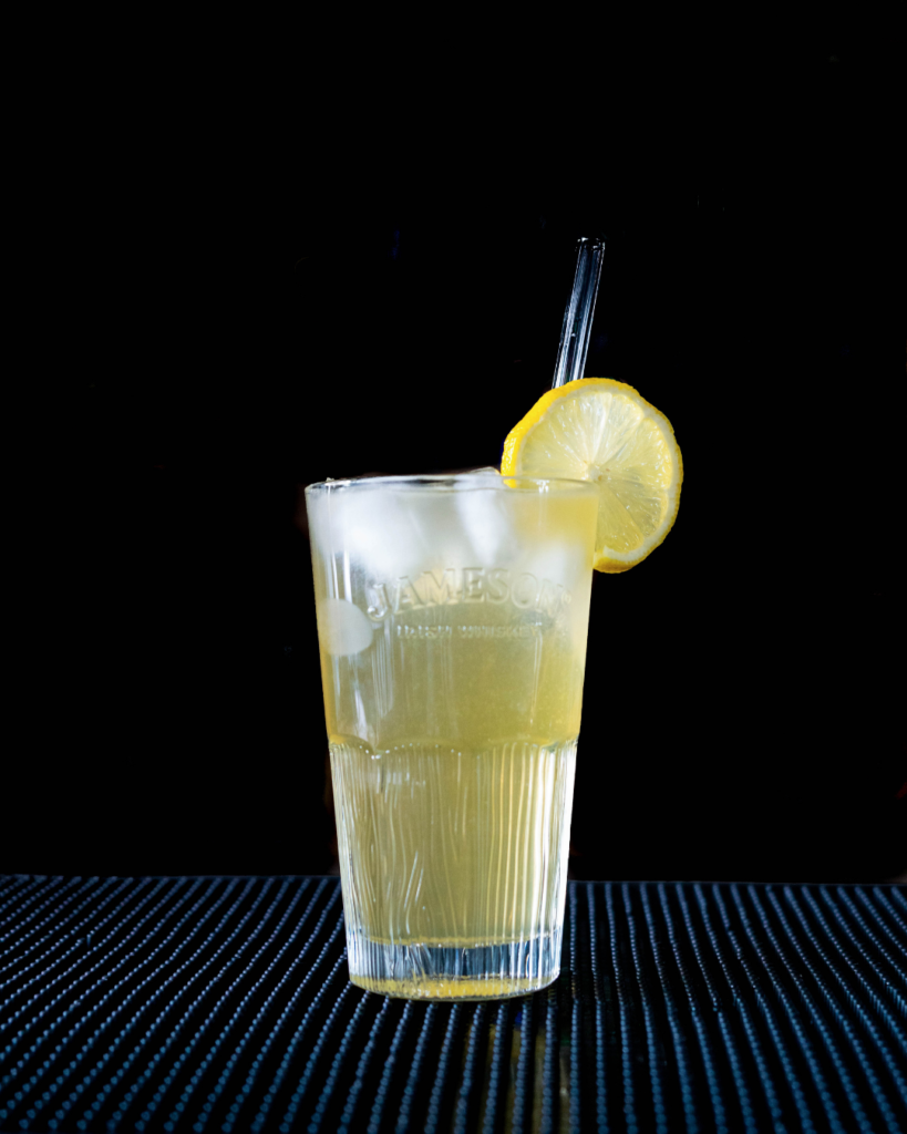 The Irish Lemonade on a bar top with a black background.