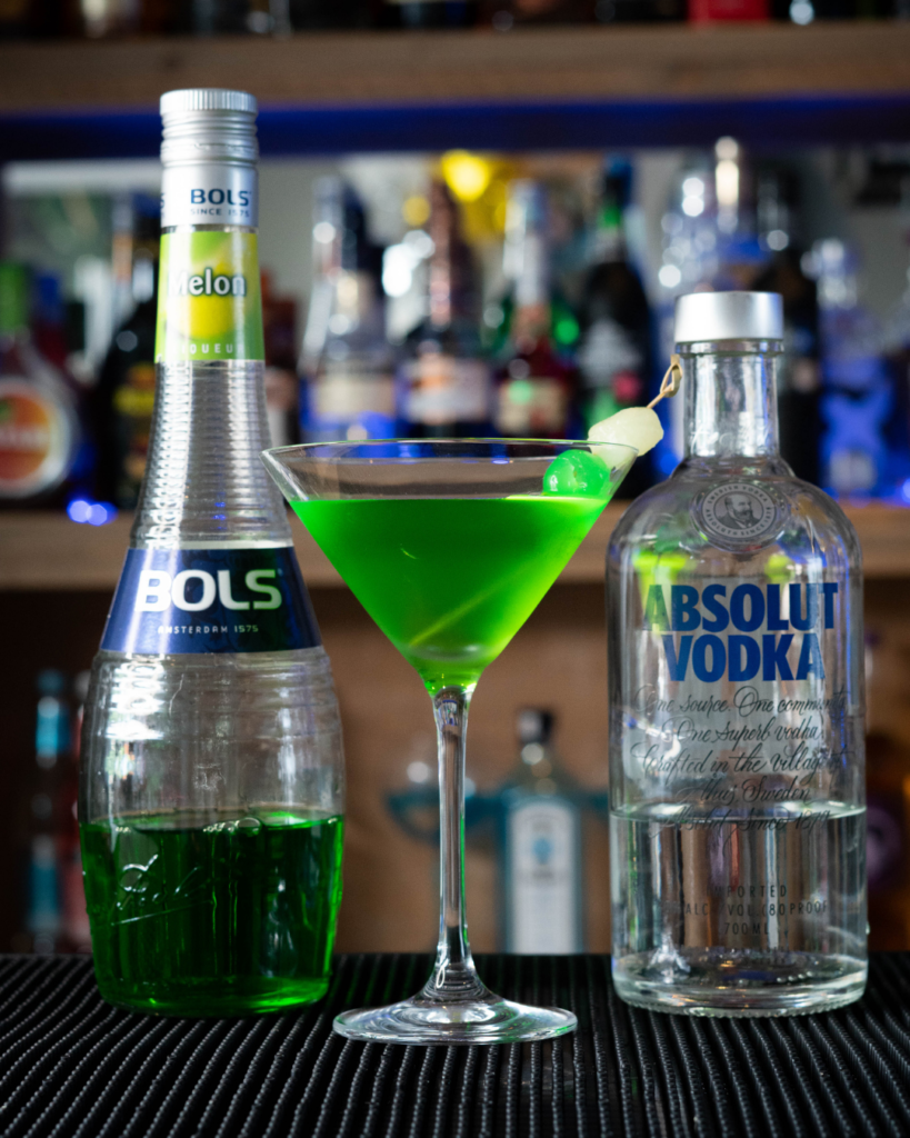 The Melontini on a bar top, surrounded by its ingredients.