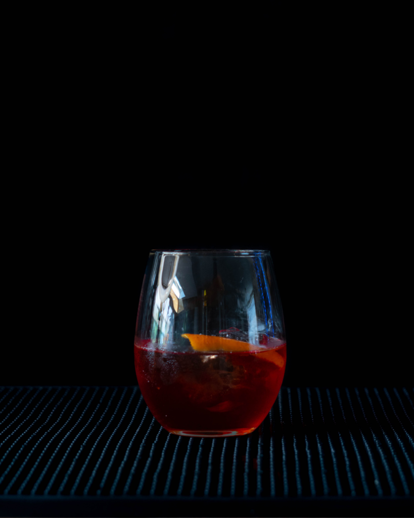 The Negroni on a bar countertop with a black background