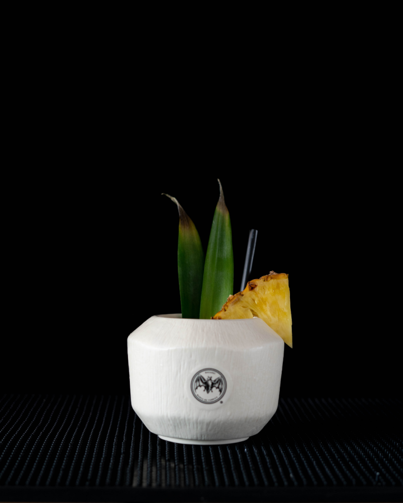 The Piña Colada on a bar top with a black background.