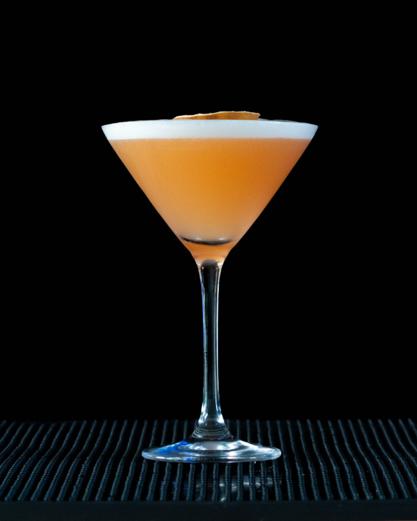 The Pornstar Martini on a bartop with a black background.