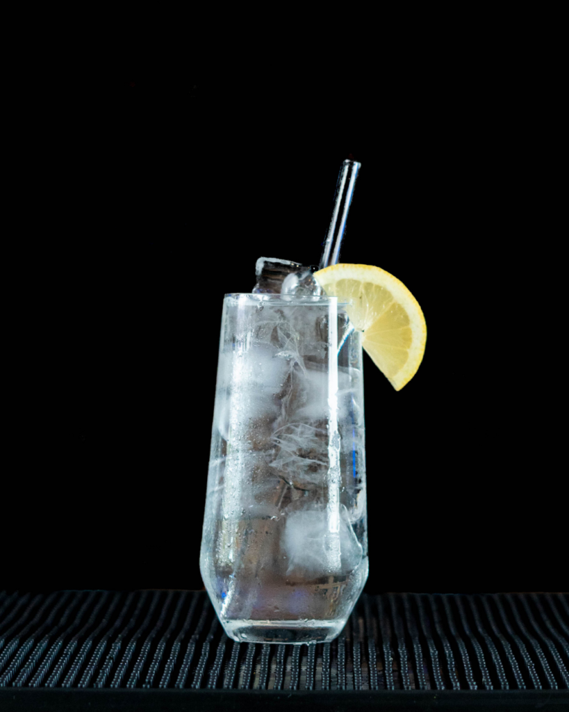 The Vodka Soda on a bar countertop with a black background