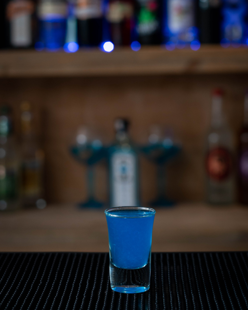 The Blue Kamikaze Shot on a bar countertop