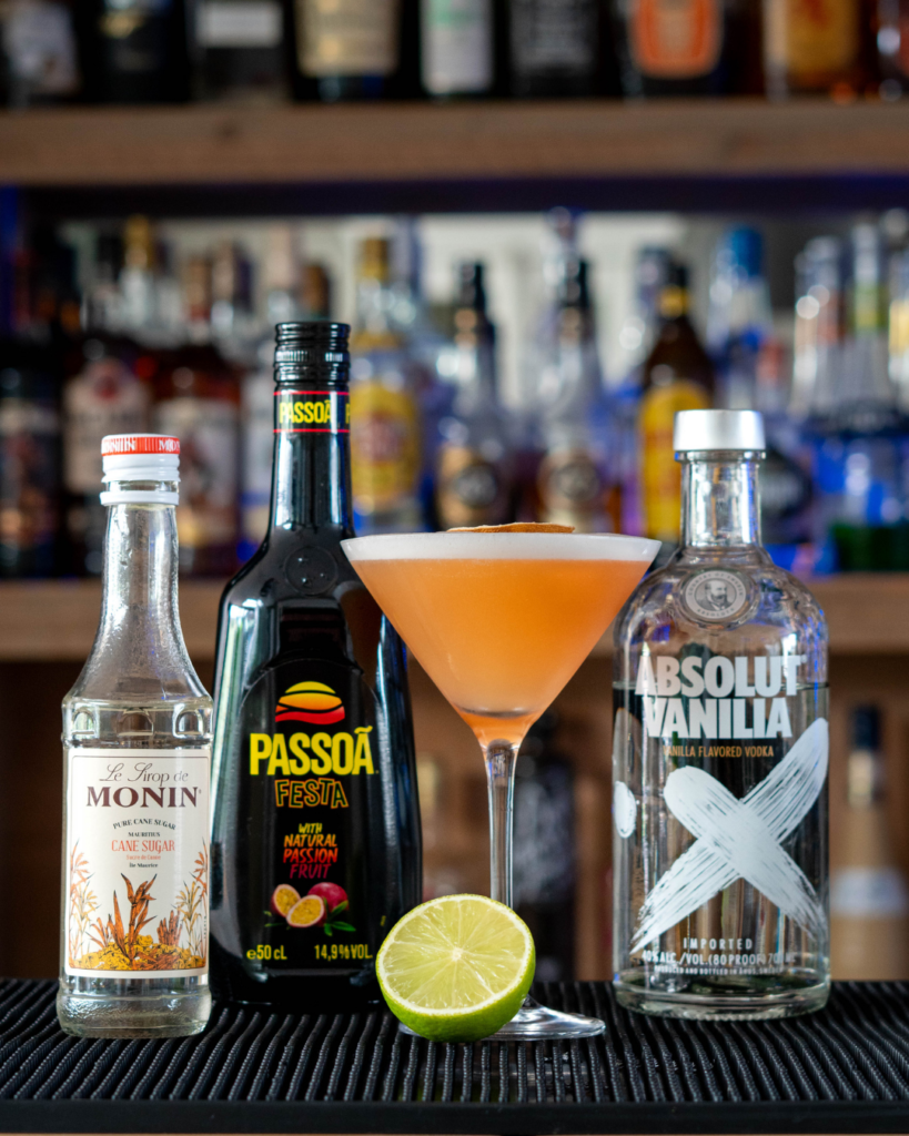 The Pornstar Martini on a bartop, surrounded by its ingredients