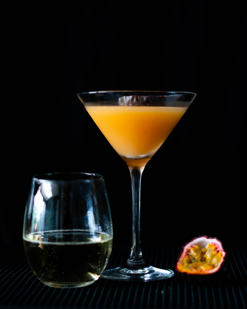 The Pornstar Martini (The Original) on a bar countertop with a black background