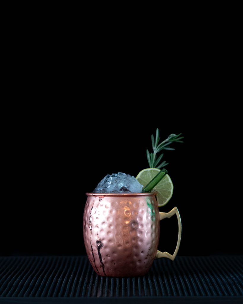 The Cranberry Mule on a bartop with a black background