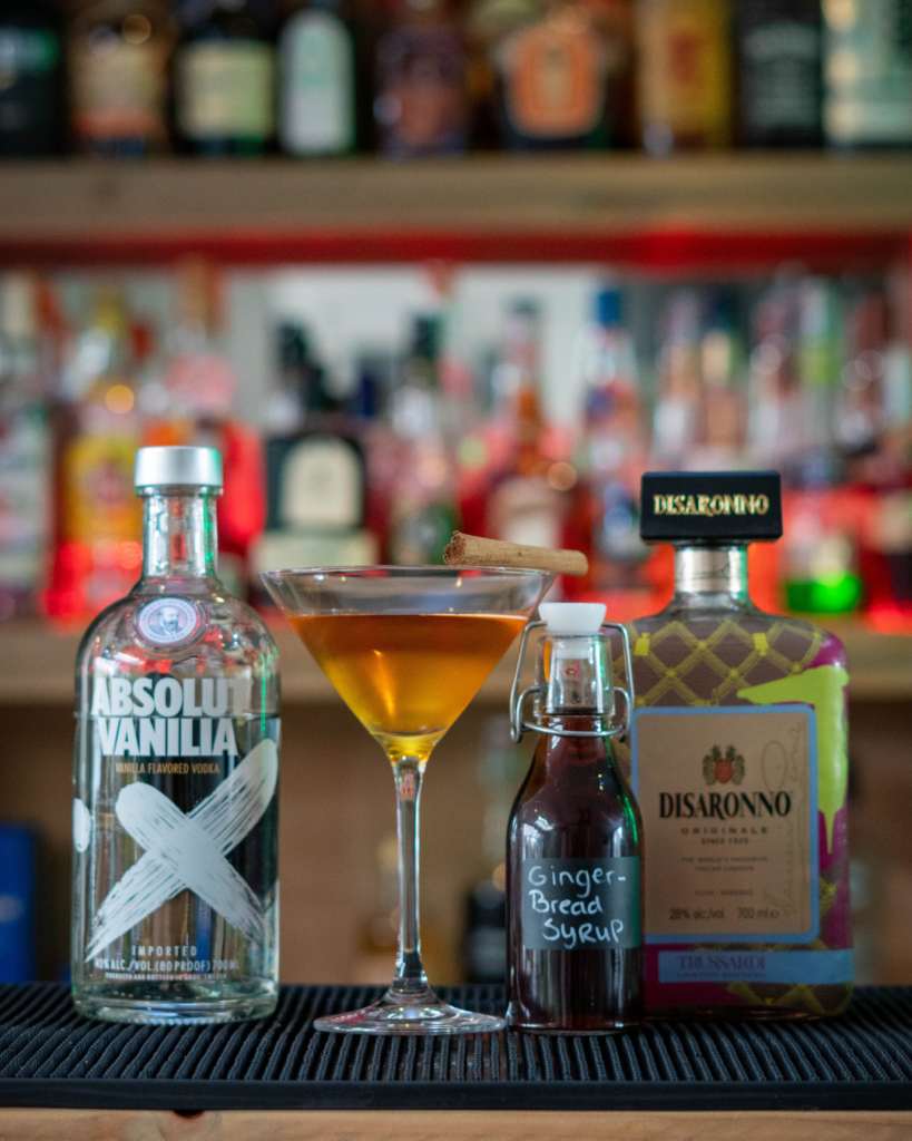 The Gingerbread Martini on a bartop, surrounded by its ingredients