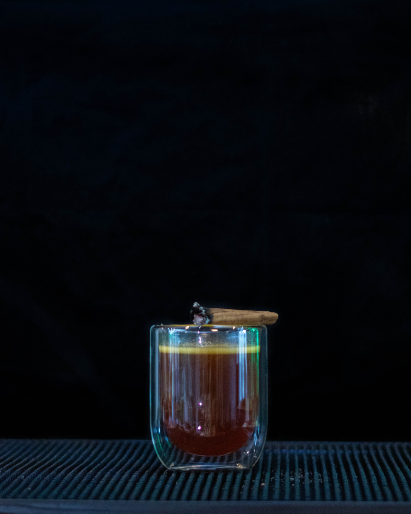 Hot Buttered Rum on a bartop with a black background