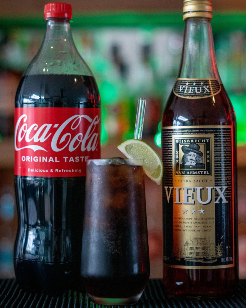 The Cola Tic on a bar top, surrounded by its ingredients.