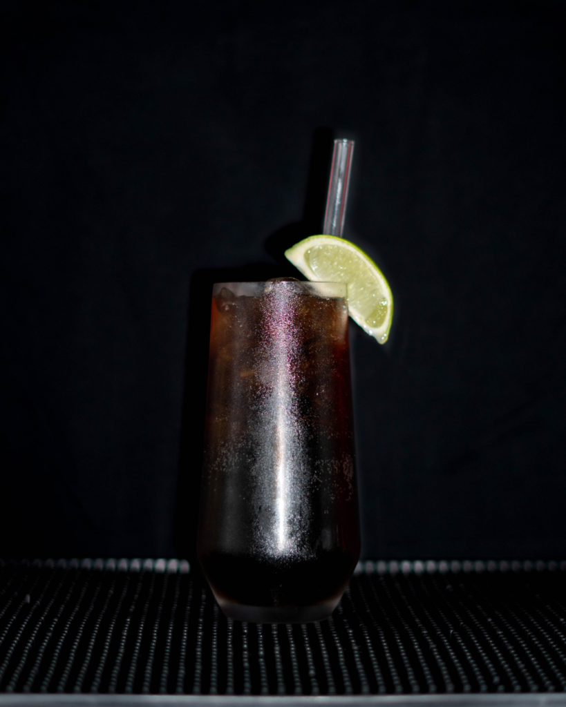 The Cola Tic on a bar top with a black background.