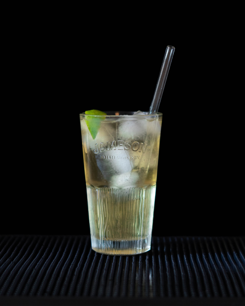 The Jameson Ginger & Lime (JGL) cocktail on a bartop, with a black background