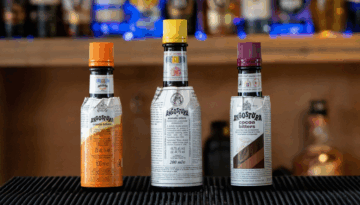 3 bottles of Angostura bitters on a home bartop. Left to right: Angostura Orange Bitters, Angostura Bitters, Angostura Cacao Bitters.