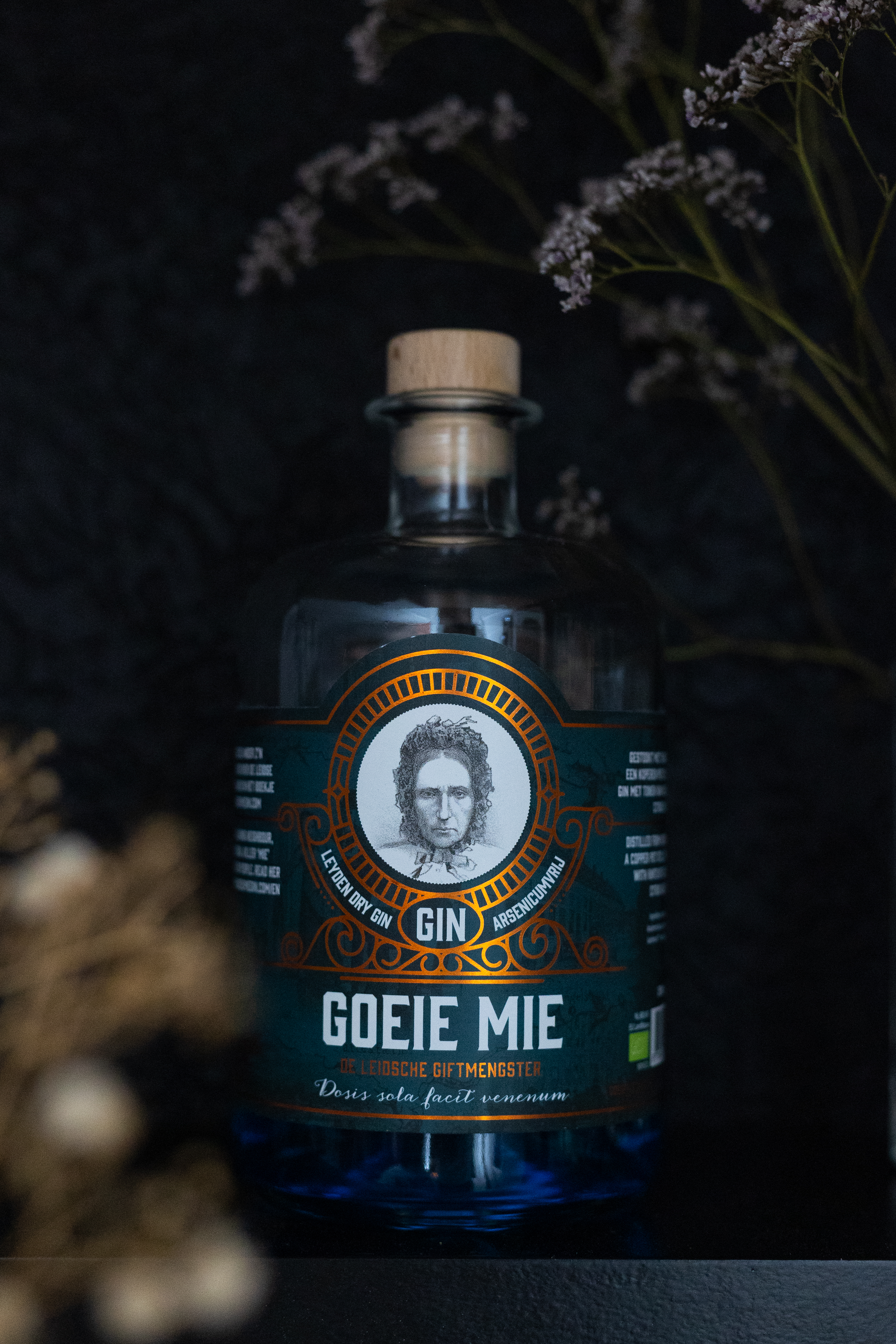 Goeie Mie gin bottle with a black background and dried flowers on a Home Bar top
