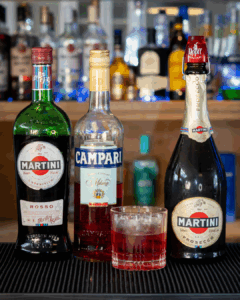 The Negroni Sbagliato surrounded by its ingredients on a home bartop.