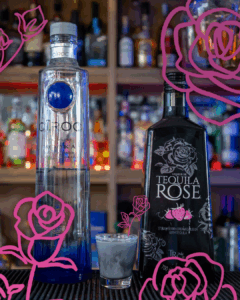 Black Rose Halloween Shot surrounded by its ingredients on a home bar top.