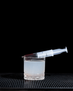 The Bloody Gin Fizz Halloween Cocktail on a home bartop with a black background.