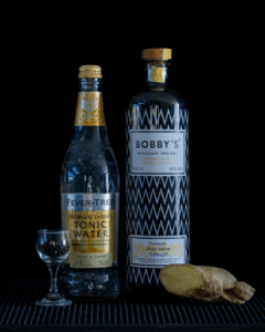 Bobby's Pinang Raci Gin & Fever-Tree Indian Tonic Water mixed on a home bartop with a black background.