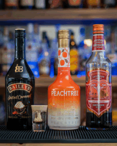 The Brain Hemorrhage Shot on a home bartop, surrounded by its ingredients
