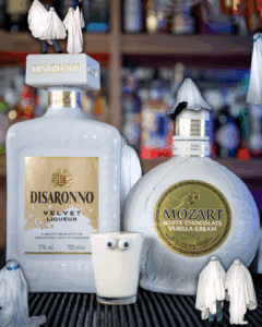 Casper the Ghost Halloween Shot with its ingredients and people with ghost costumes on a home bar top.