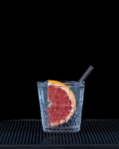 Empress 1908 Gin & Fever-Tree elderflower Tonic Water mixed on a home bartop with a black background.