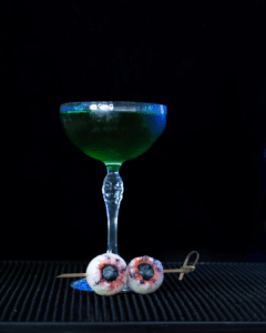 The Eye See You Halloween cocktail on a home bartop with a black background