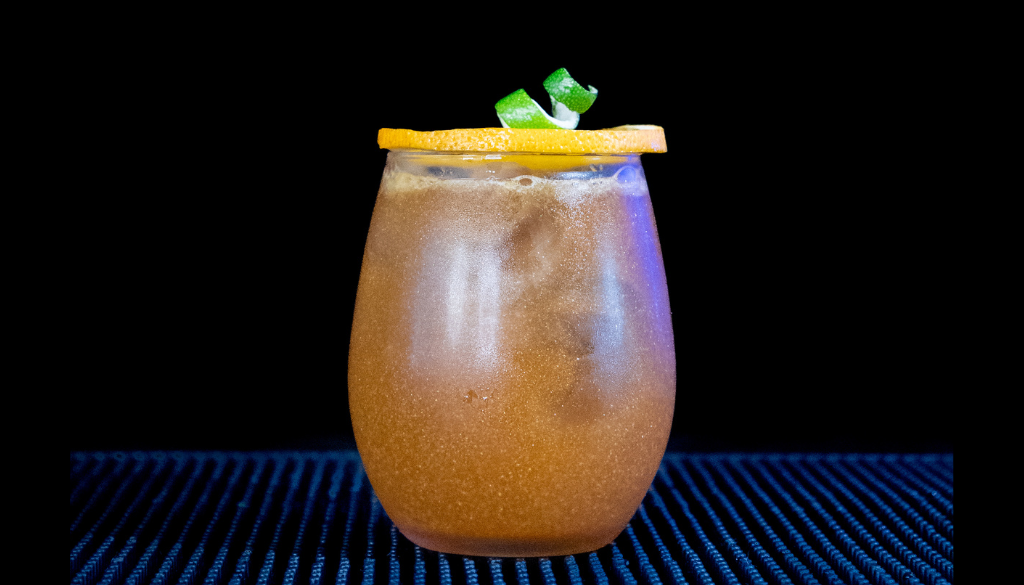 The Jack-'o'-Lantern Halloween Cocktail on a home bartop with a black background.