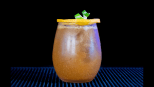 The Jack-'o'-Lantern Halloween Cocktail on a home bartop with a black background.