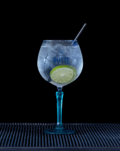 Gin & Tonic: Rutte Kaffir Lime Gin & Fever-tree Mediterranean Tonic mixed on a home bartop with a black background.