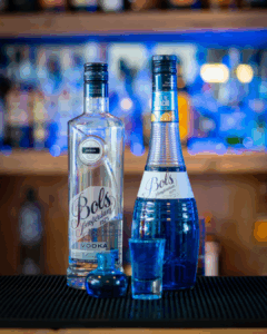 The Boo-zy Lab Kit, Halloween shots; the blue shot. The shots on a home bartop, surrounded by its ingredients.