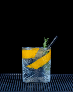 Black Forest Wild Gin & Fever-Tree Mediterranean Tonic Water mixed on a home bartop with a black background.