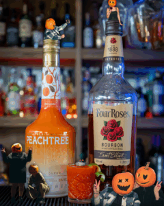 The Brain Hemorrhage Shot on a home bartop, surrounded by its ingredients and pumpkinhead photoshoot.