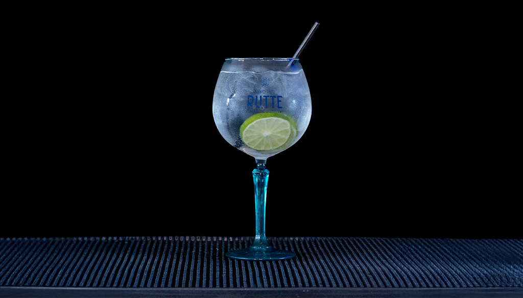 Gin & Tonic: Rutte Kaffir Lime Gin & Fever-tree Mediterranean Tonic mixed on a home bartop with a black background.