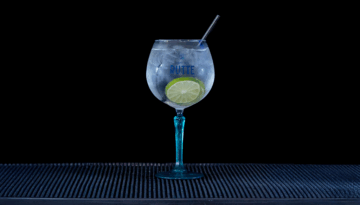 Gin & Tonic: Rutte Kaffir Lime Gin & Fever-tree Mediterranean Tonic mixed on a home bartop with a black background.