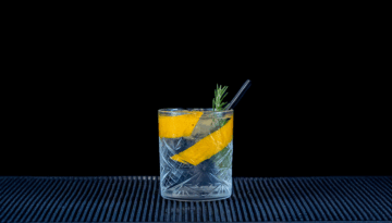 Black Forest Wild Gin & Fever-Tree Mediterranean Tonic Water mixed on a home bartop with a black background.