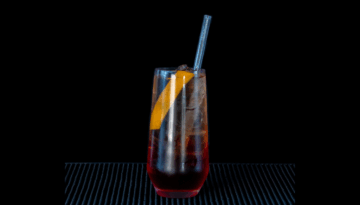 the Americano cocktail on a home bartop with a black background.