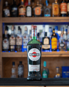 A bottle of Martini Rosso, Sweet Vermouth, on a home bar top.