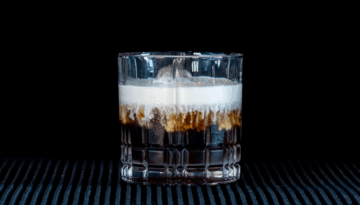 The White Russian on a home bartop, with a black background.