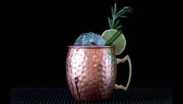 The Cranberry Mule on a bartop with a black background
