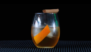 The gingerbread old fashioned on a home bartop with a black background.