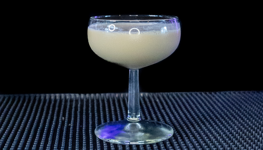 The P.S. I Love You cocktail on a home bar top with an all black background