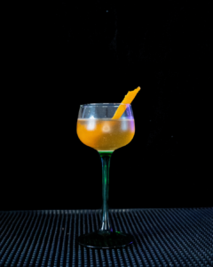 The Between the Sheets cocktail on a home bar with an all black background