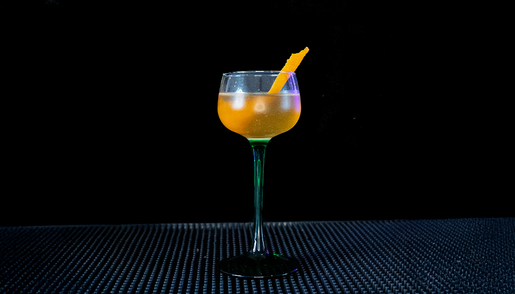 The Between the Sheets cocktail on a home bar with an all black background