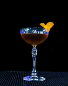 The Bridal Suite cocktail on a home bar top with an all black background