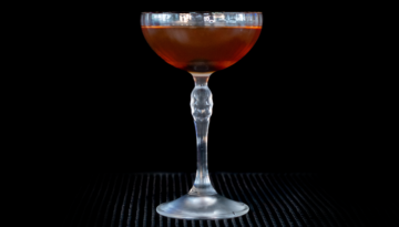 The Manhattan on a home bar top with an all black background
