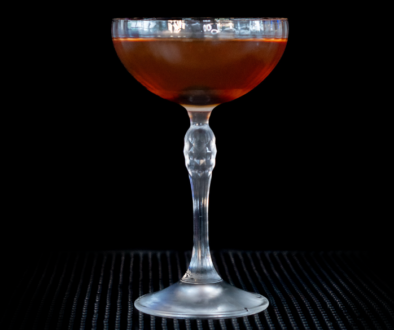 The Manhattan on a home bar top with an all black background