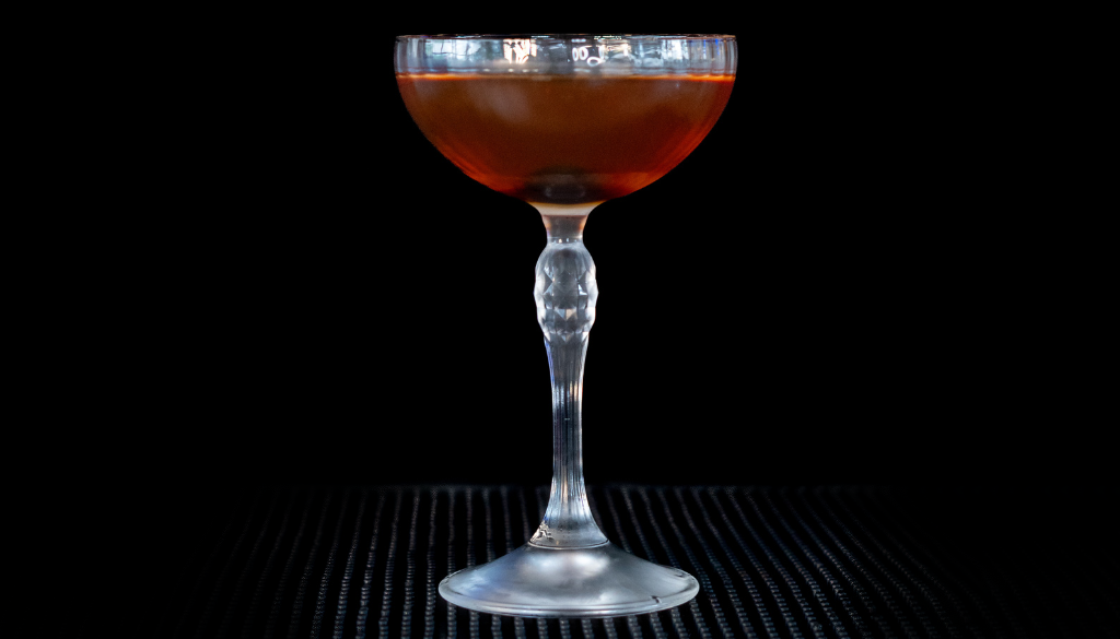 The Manhattan on a home bar top with an all black background