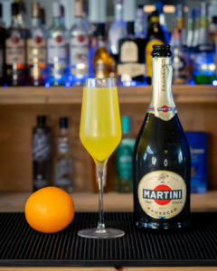 The Mimosa on a home bar top, surrounded by its ingredients